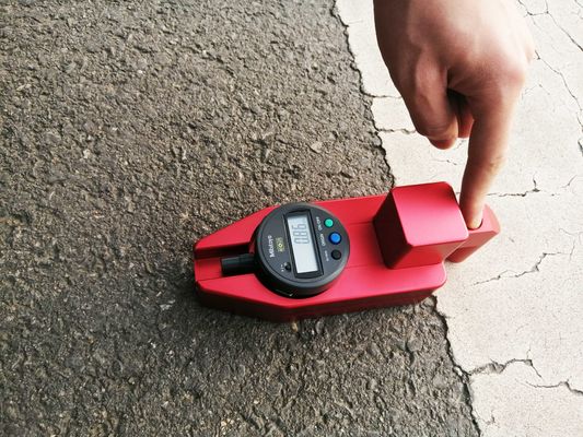 Czerwone oznaczenia na chodniku Miernik sprawdzający grubość Bateria sucha